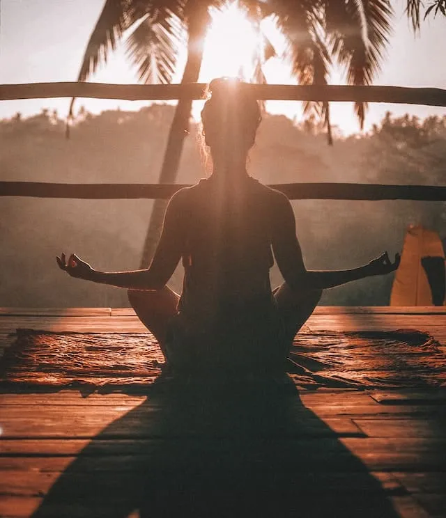 Mujer haciendo Yoga en balcón Playa